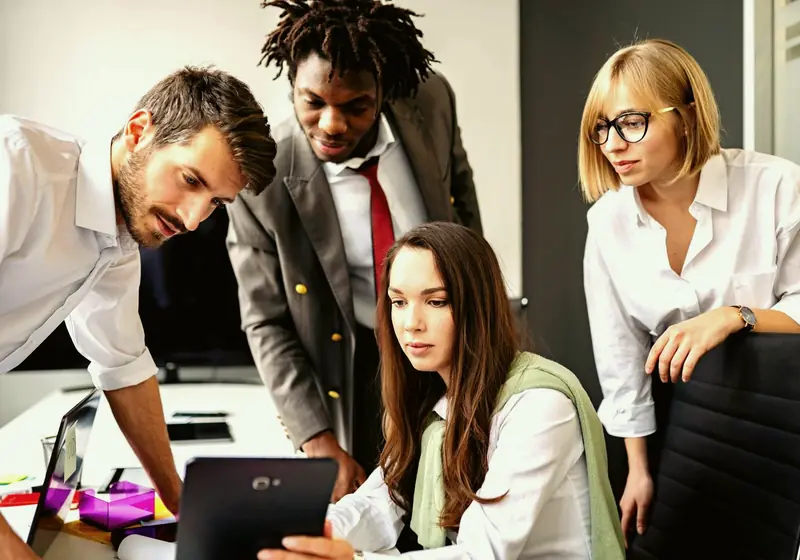 A small team gathered around a tablet, reviewing a design together (stock photo)